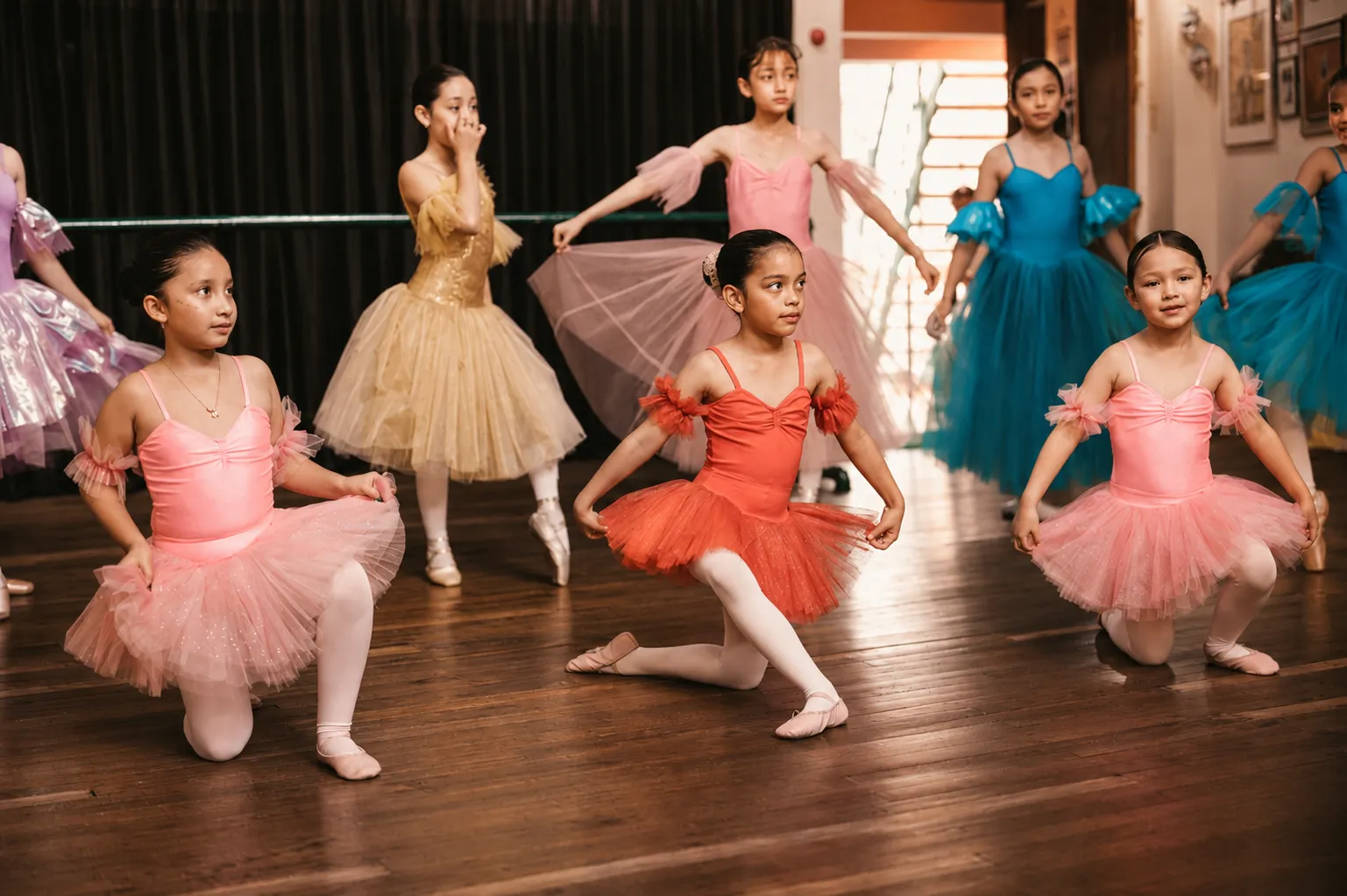 Cuatro niñas en plié sobre el escenario