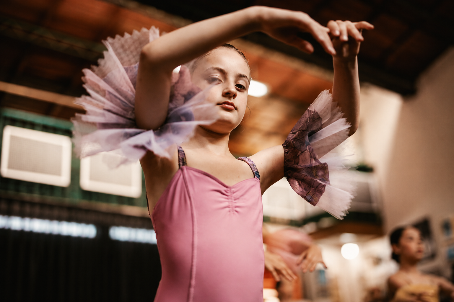 Bailarina joven en arabesque durante clase de ballet clásico