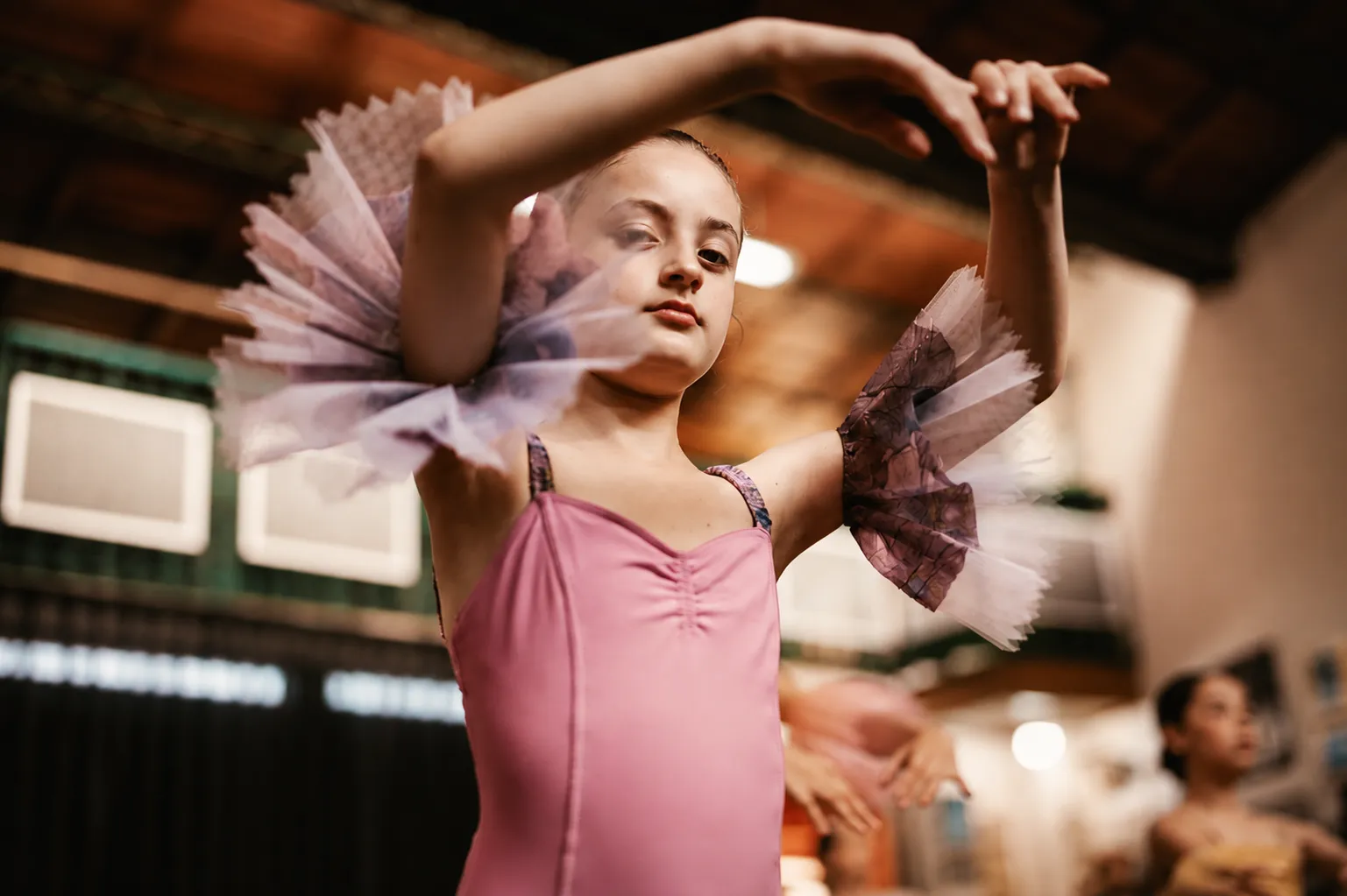 Bailarina joven en arabesque durante clase de ballet clásico